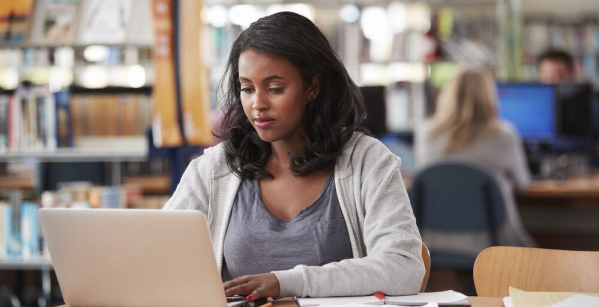 A finance student works on a laptop at the university