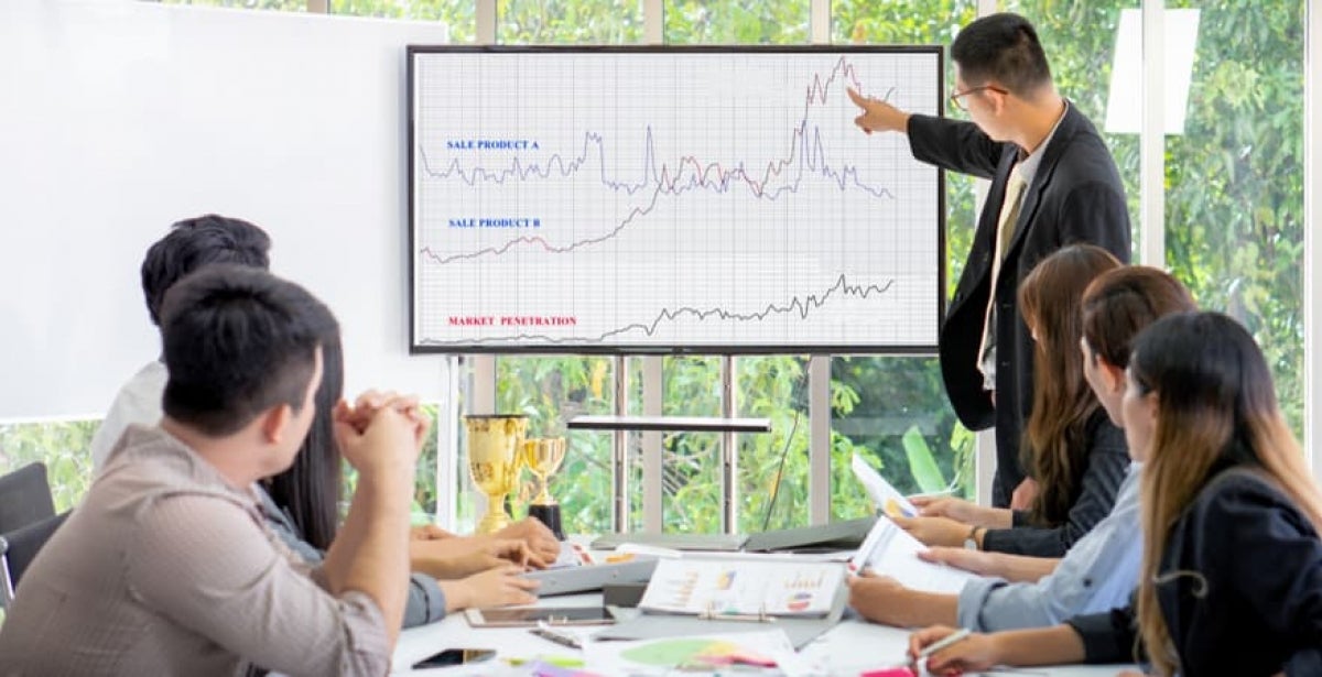 A data scientist presenting some information to colleagues on a computer screen.