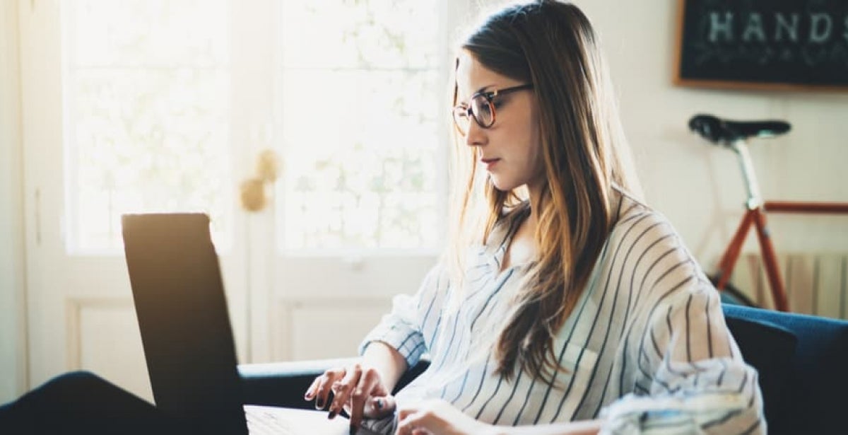 A female postgraduate student studying online in her quiet study space at home.