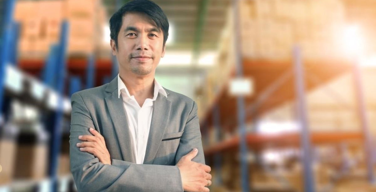 A social entrepreneur standing and smiling with his arms crossed