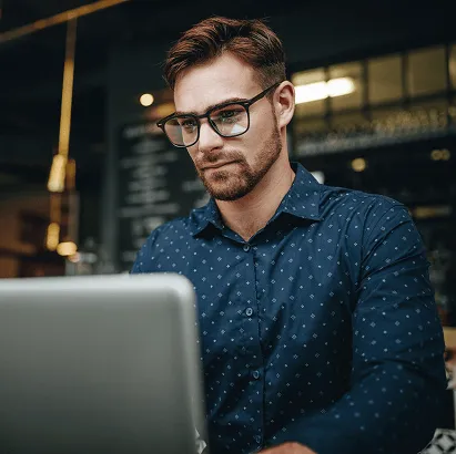 Professional using a laptop in a modern indoor workspace.
