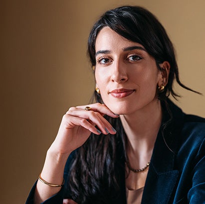 Portrait of a woman in a striking black business suit.