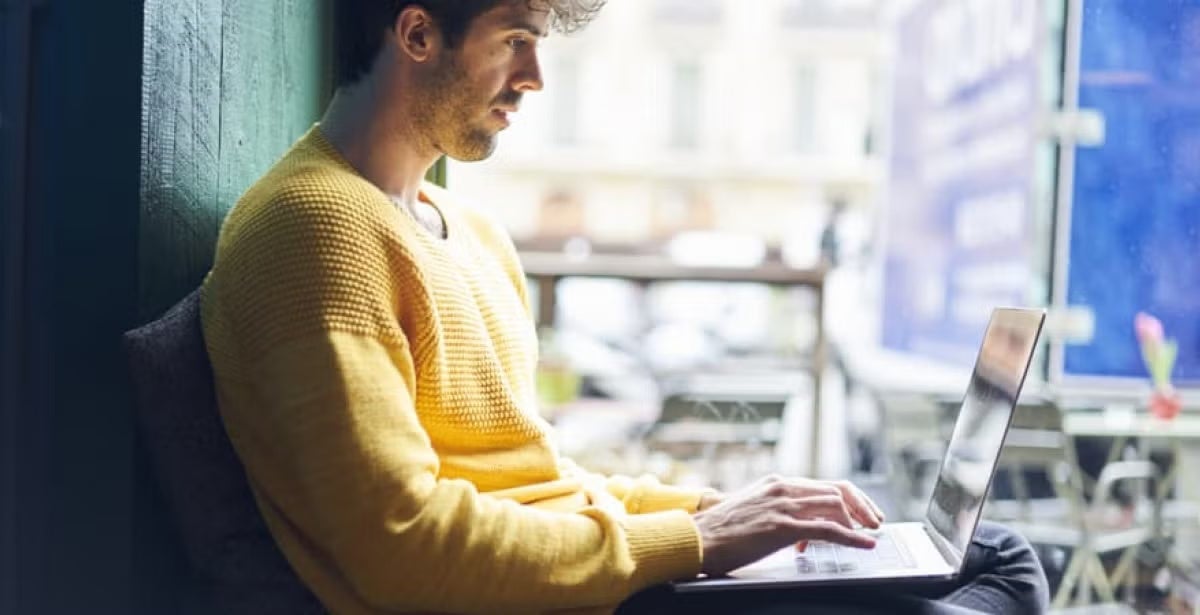 A data scientist working on a laptop in a start-up office