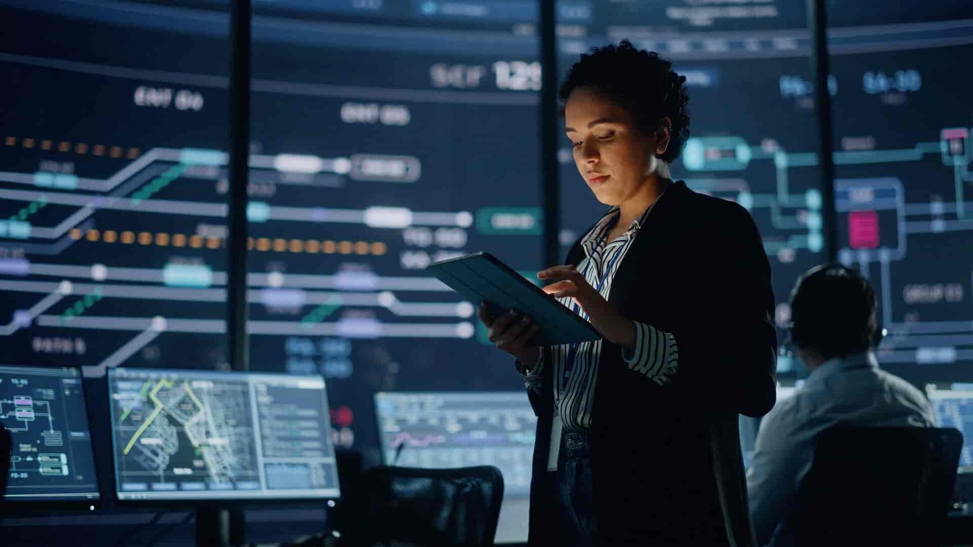 A cyber security examines a tablet, focused on her task.